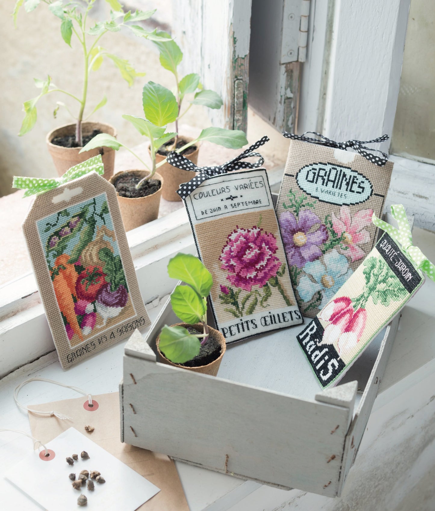 Grille broderie point de croix : sachet de graines 3 fleurs pour jardiniers. 4 pages, symboles et couleurs DMC. Lin 11 fils blanc. 11 x 17 cm.