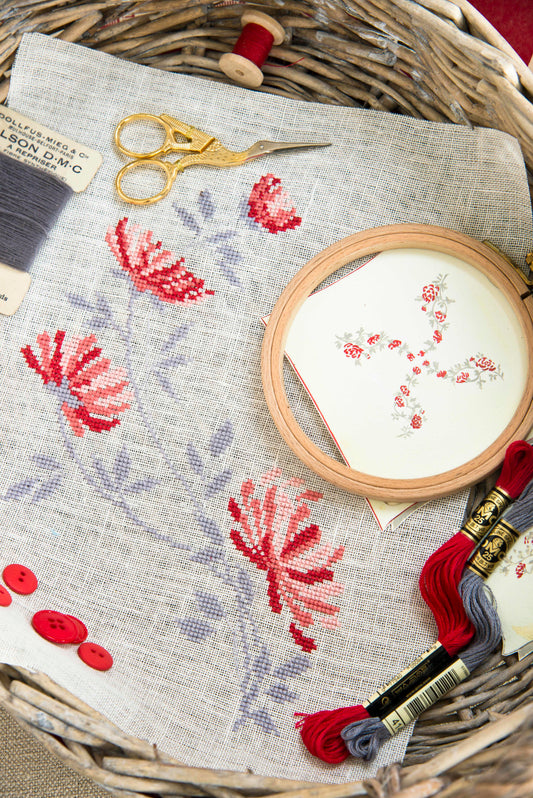 Grille point de croix – Atelier de broderie, vue d'ensemble : composition 91×125 pts recréant l'atmosphère d'une ancienne mercerie avec broderies et objets décoratifs – Création Point de Croix