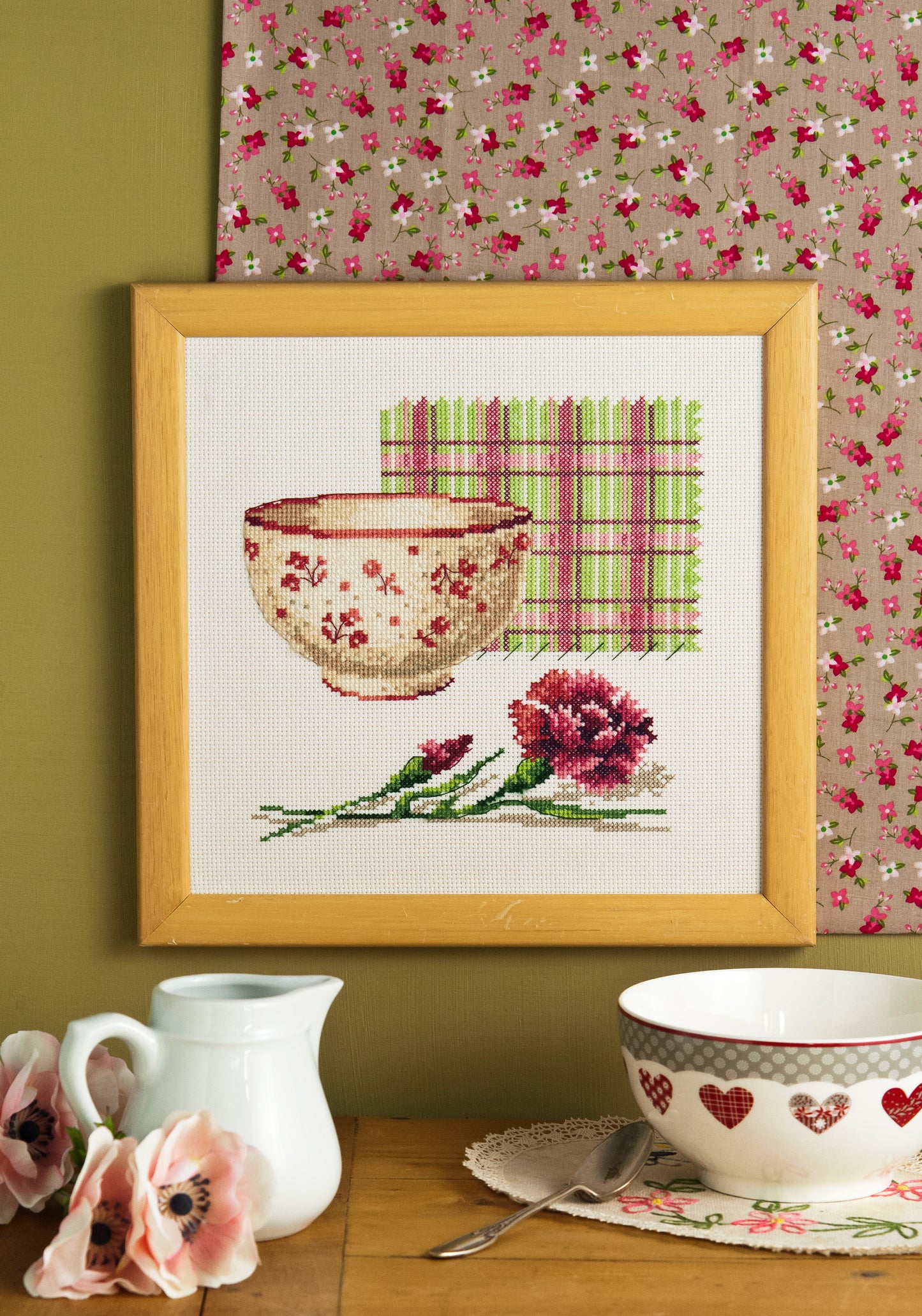 Grille point de croix – Bol œillets : bol fleuri accompagné d'un bouquet d'œillets roses et rouges sur tissu à carreaux, ambiance champêtre et romantique – Création Point de Croix