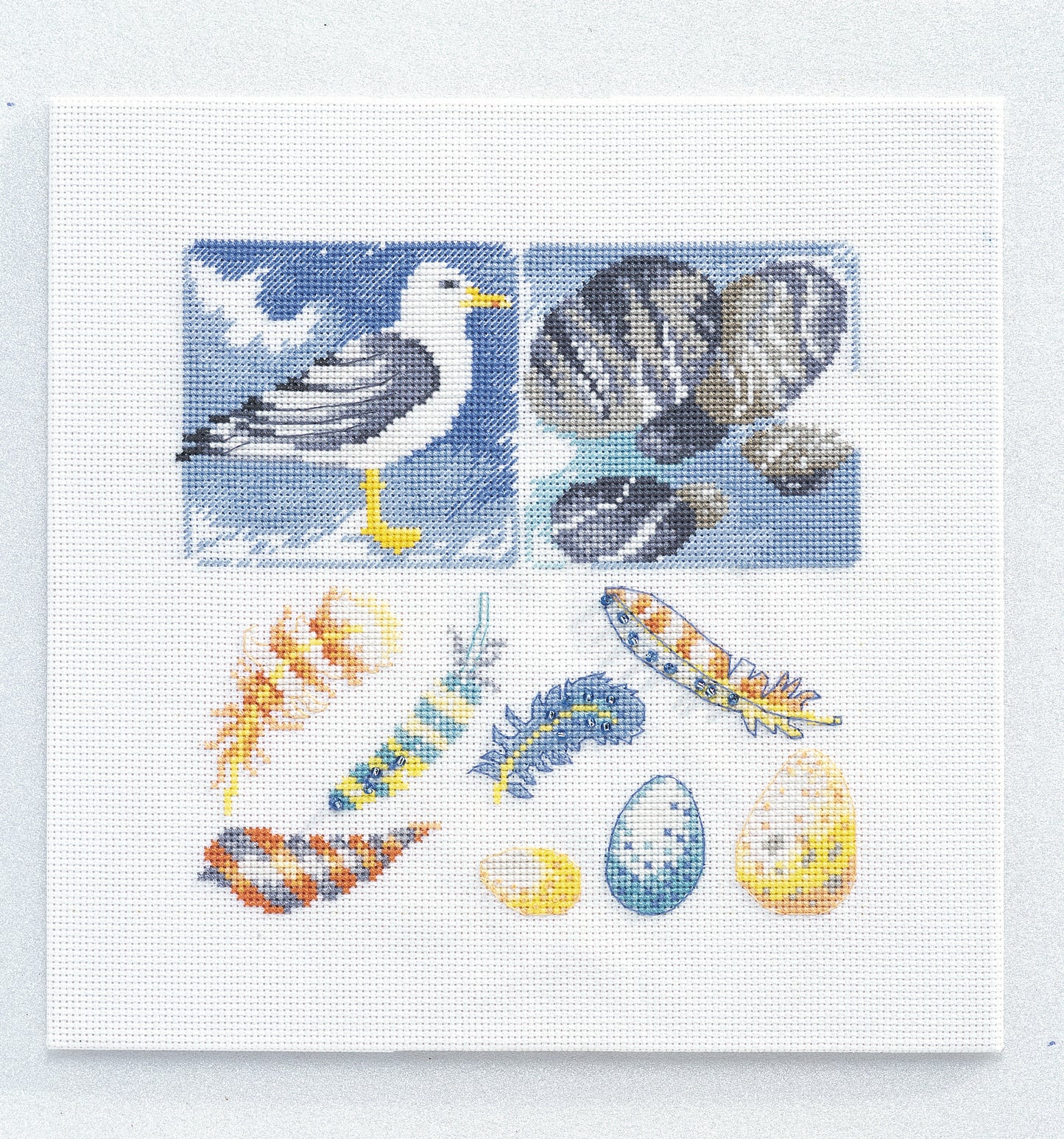 Grille de point de croix Escales en Bord de Mer – cadre Mouette et trésors du rivage, coquillages et plumes brodés, 85×85 pt, environ 15,5×15,5 cm, sur lin naturel 11 fils/cm, Création Point de Croix