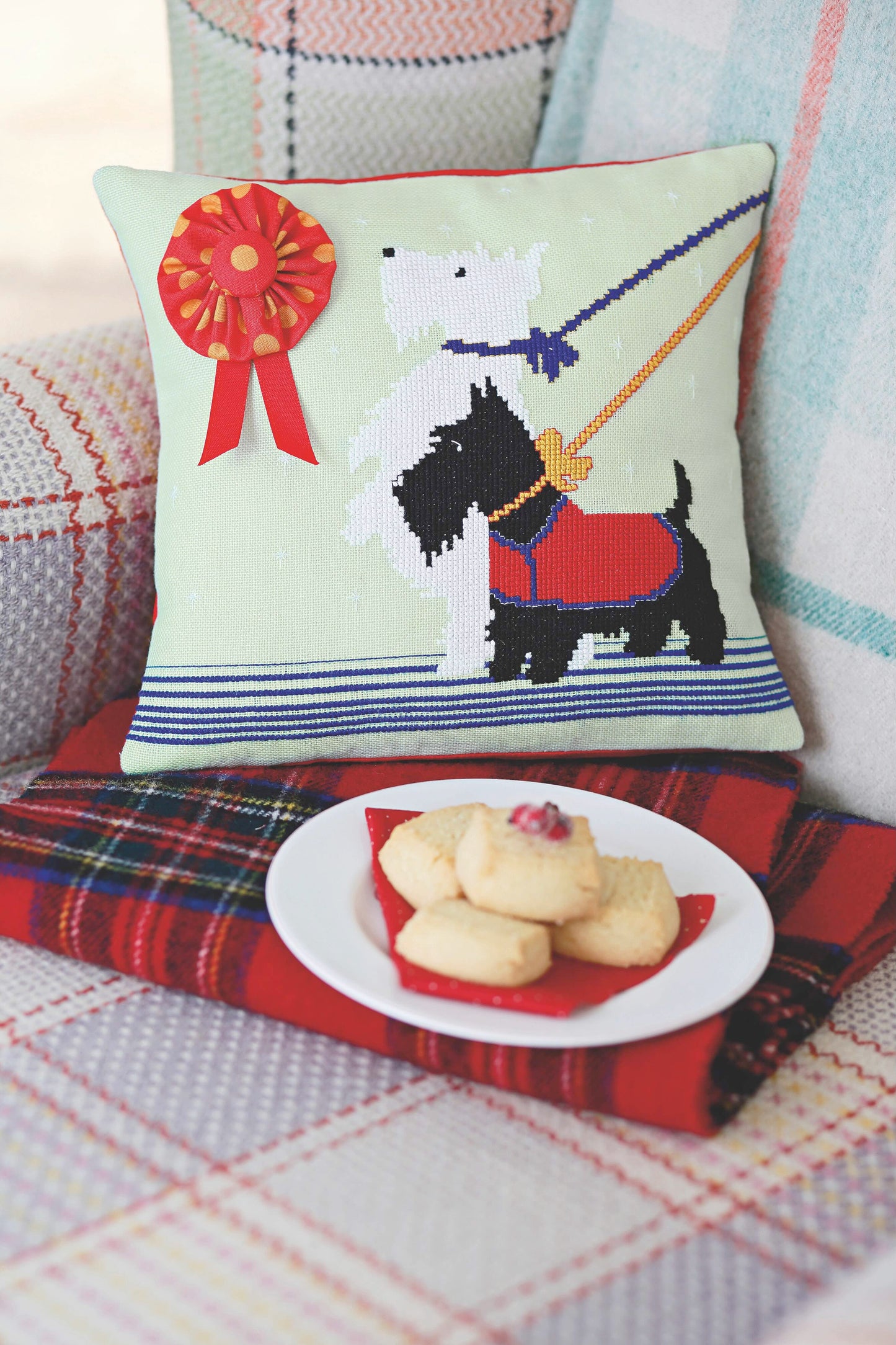 Grille de point de croix Coussin Mes petits scotties : terriers écossais sur toile vert pâle. 108 x 135 points. Références DMC sur 4 pages.