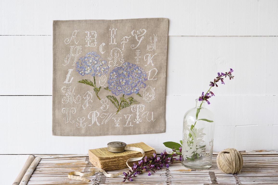 Grille de broderie au point de croix : Des lettres et des hortensias, alphabet ornemental et hortensias bleus. 6 pages avec symboles et références DMC. À broder sur lin ou Aïda.