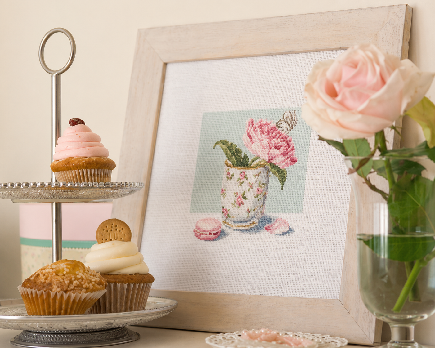 Grille point de croix – Gâteaux au thé : fleur rose dans une tasse ancienne fleurie, macarons, meringues et papillon en teintes poudrées sur toile Aïda blanc ou beige DMC – Création Point de Croix