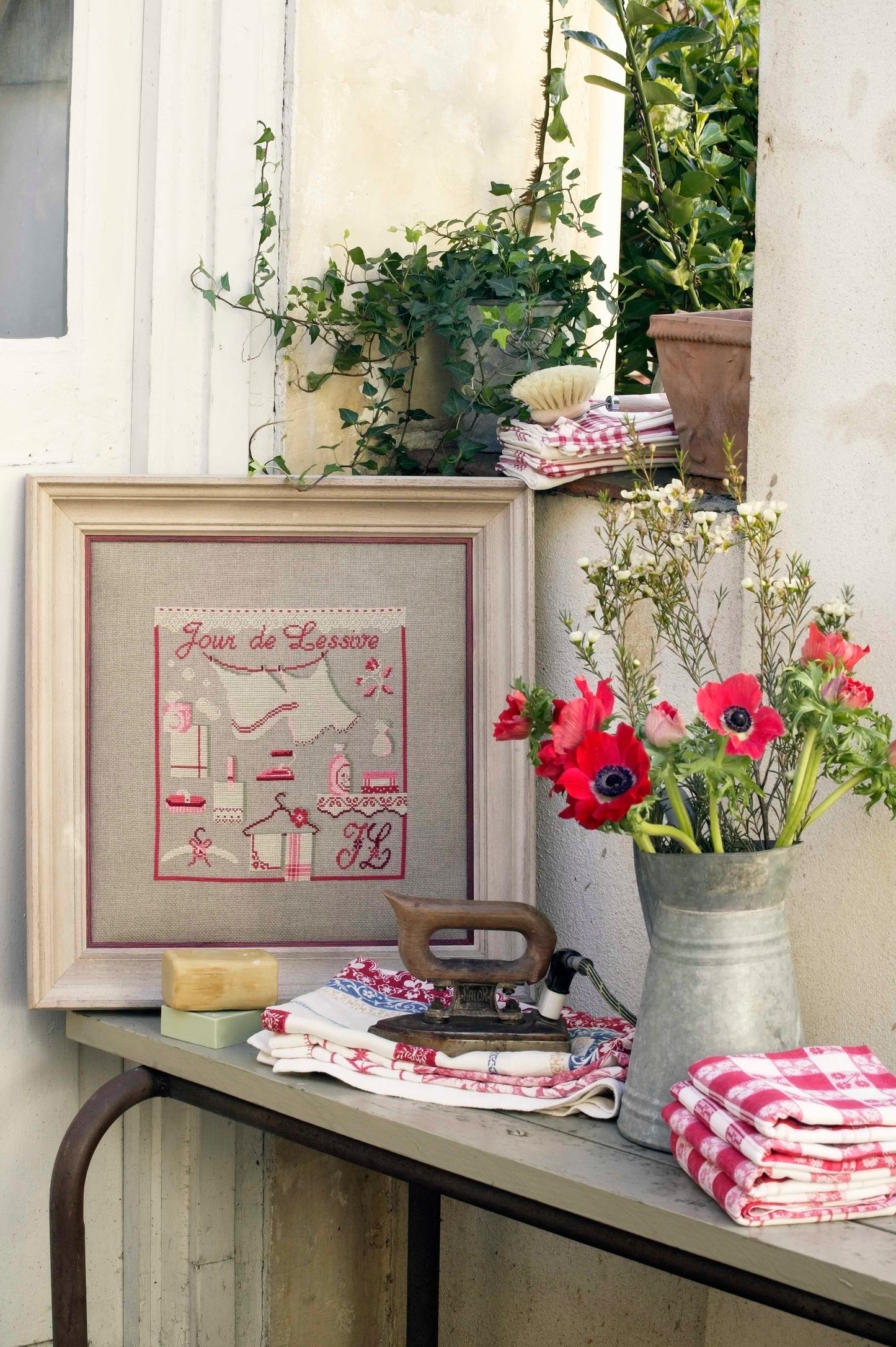 Grille broderie point de croix : tableau jour de lessive. 148 x 148 pts, imprimée en couleur sur 4 pages. Réf. DMC incluses.
