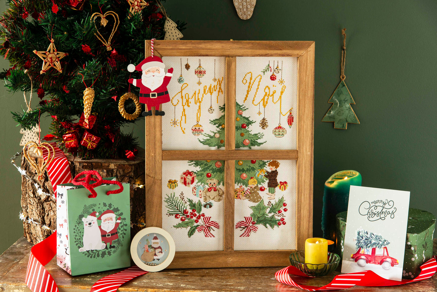 Grille broderie point de croix : fenêtre de Noël, sapin, cadeaux et houx. 10 pages, symboles et couleurs DMC. Toile Aïda ou lin écru.