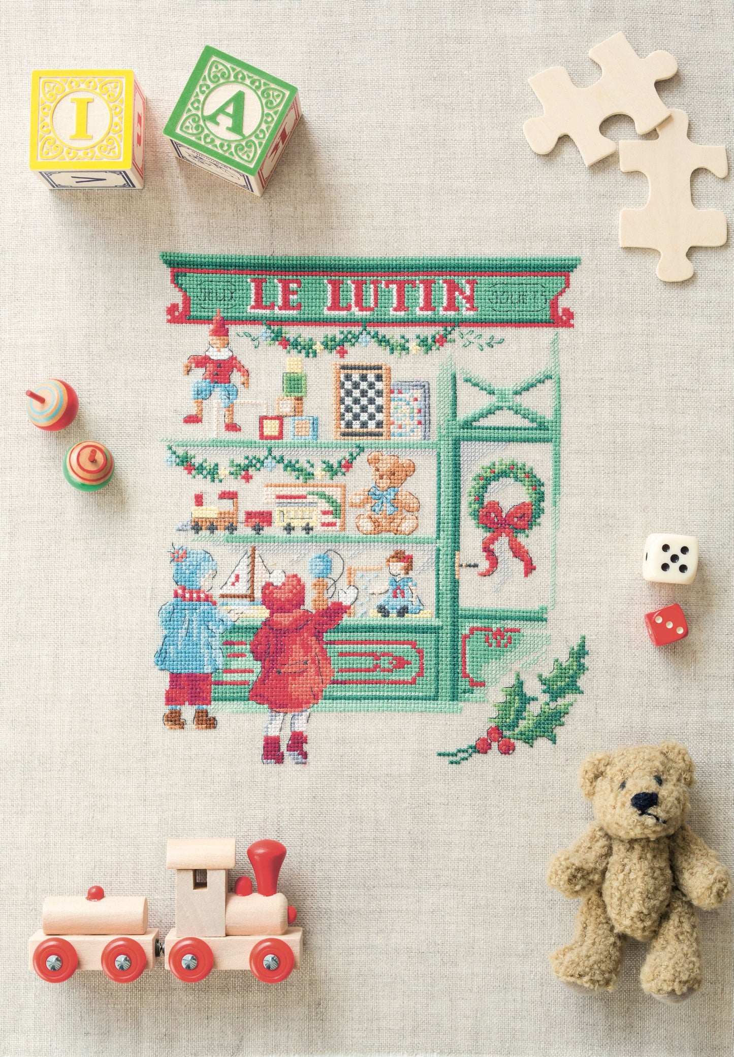 Grille de point de croix La vitrine aux jouets : jouets anciens sur lin 11 fils. 130 x 110 points. Références DMC sur 4 pages.