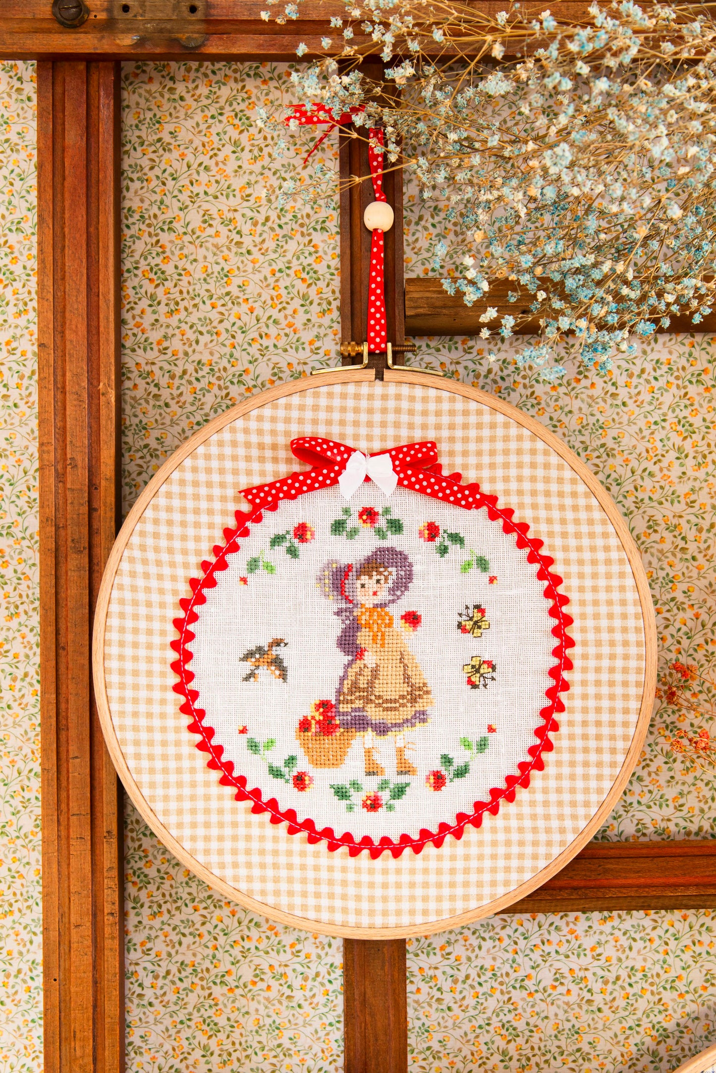 Grille point de croix : Rose et son amie au ballon dans une couronne fleurie. 74×74 pts, Aïda 5,5 pts/cm ou lin 11 fils/cm. Réf. DMC, 6 pages.