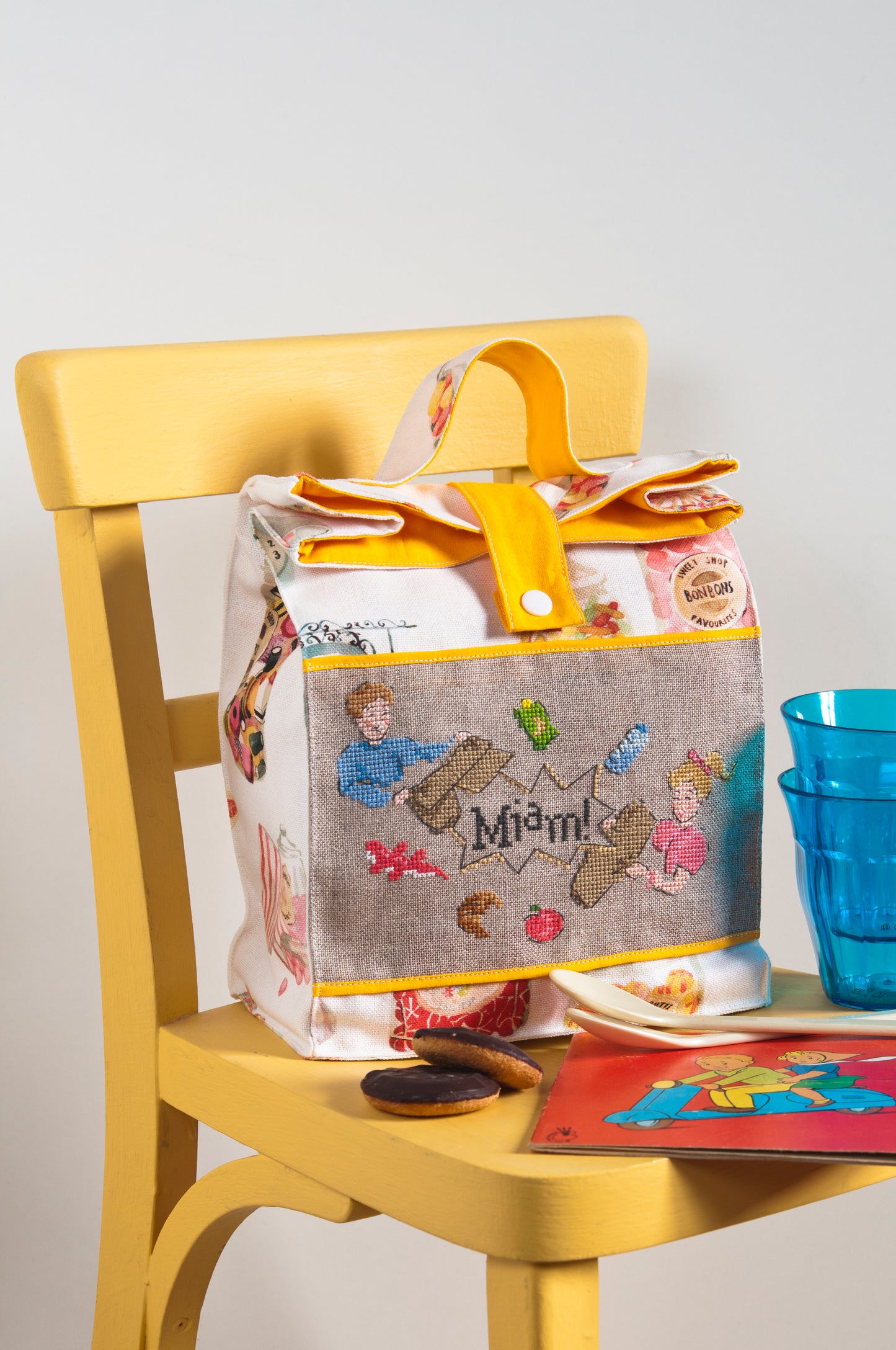 Grille de broderie point de croix : lunch bag avec jolis motifs brodés. Motif 94 x 59 pts, imprimé couleur (Réf. DMC) sur 6 pages.