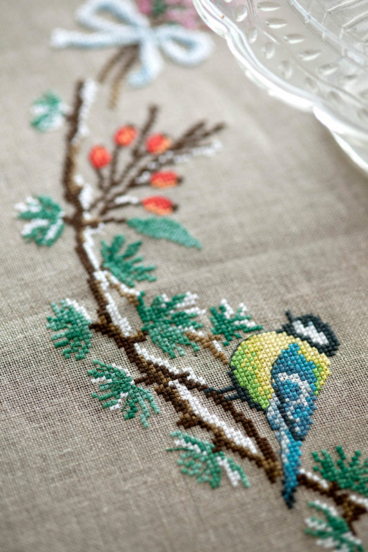 Grille de point de croix Nappe promenade en forêt : couronne florale et mésange sur lin 11 fils bis. 210 x 220 points. Références DMC sur 6 pages.