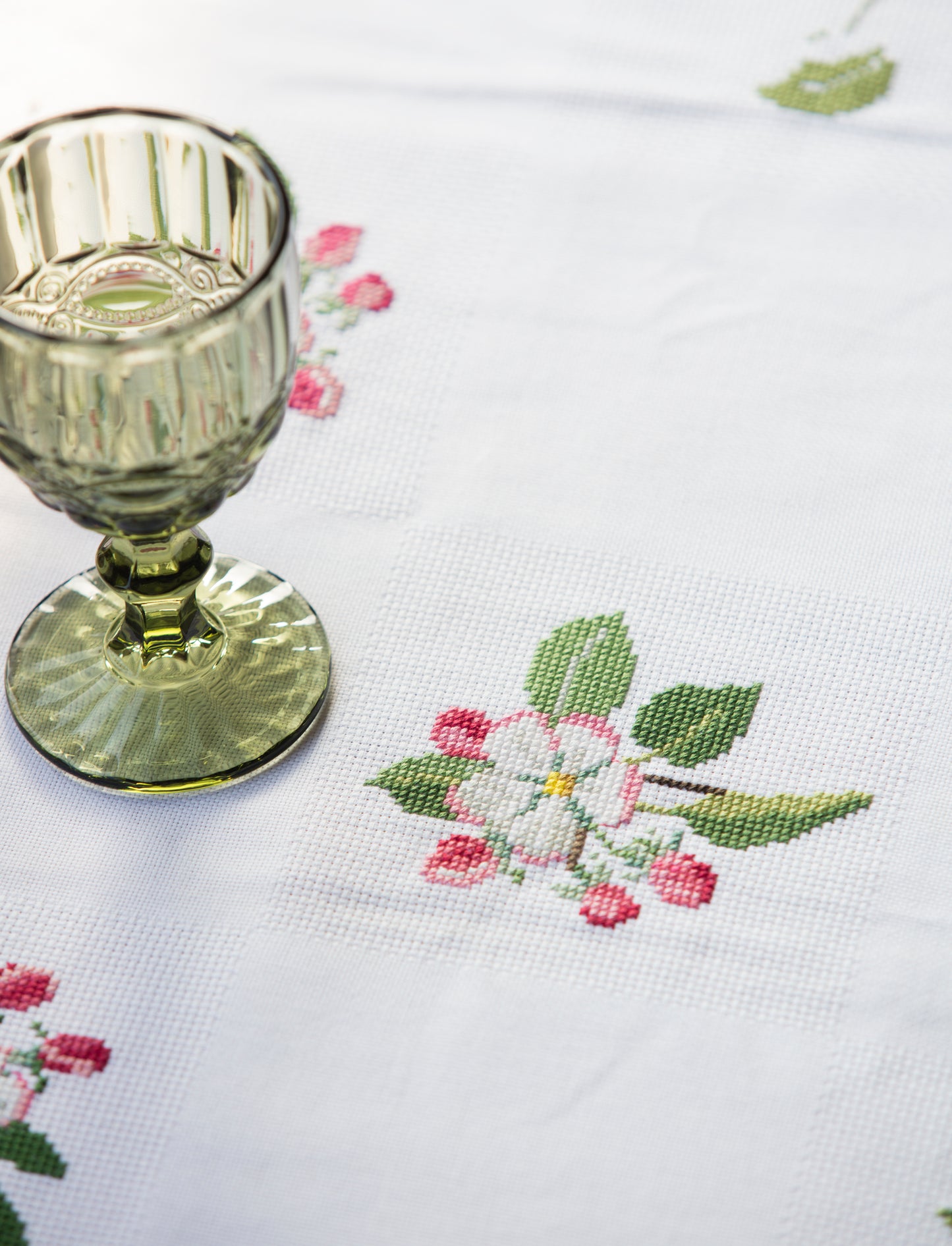 Grille point de croix : nappe roses et fleurs de pommier, 3 motifs. Aïda 5,5 pts/cm ou tissu à carreaux. Réf. DMC, 10 pages.