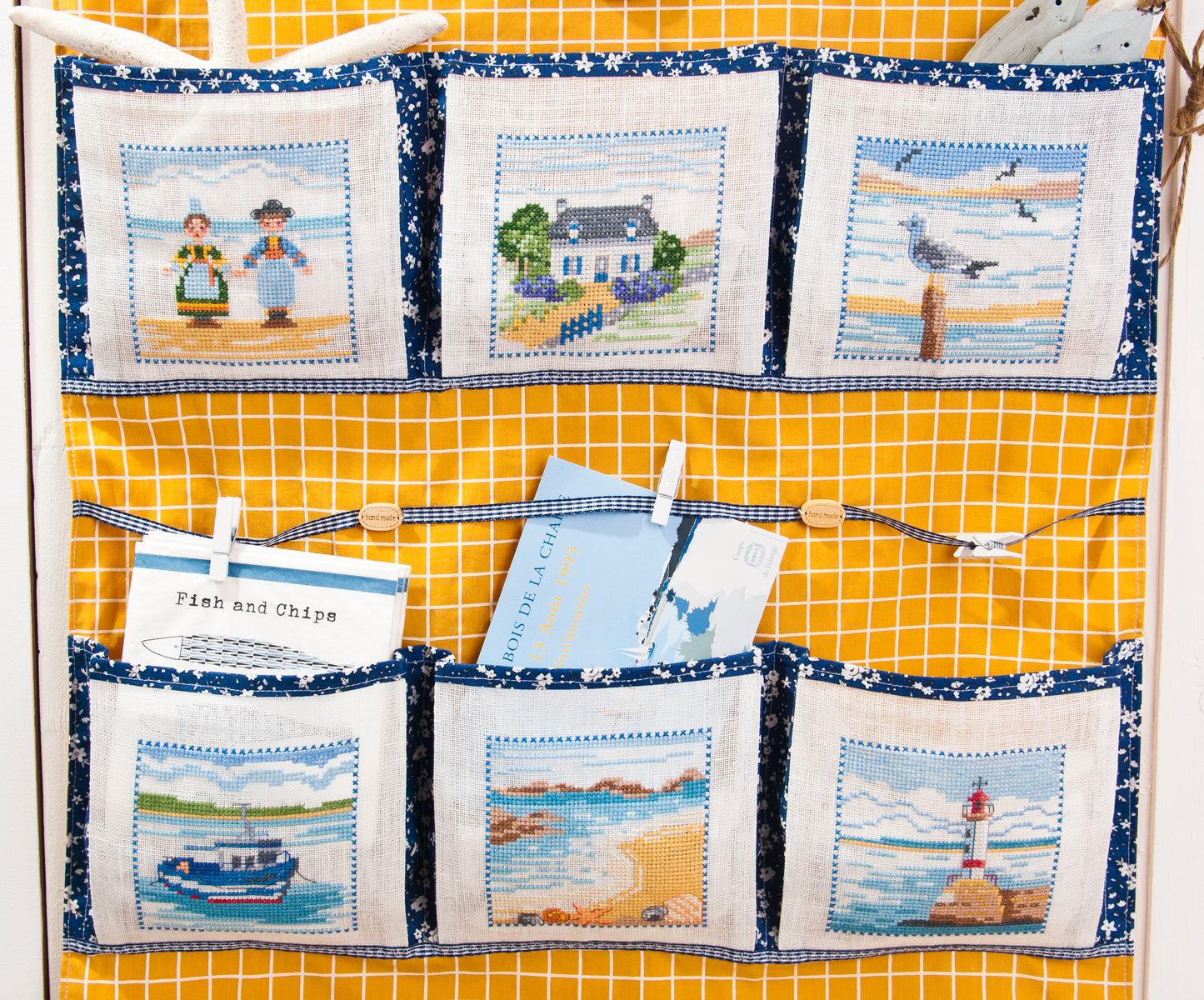 Grille de broderie point de croix : pêle-mêle Bretagne (phares, costumes, granit, paysages). Motif 51 x 51 pts, imprimé couleur (Réf. DMC) sur 6 pages.