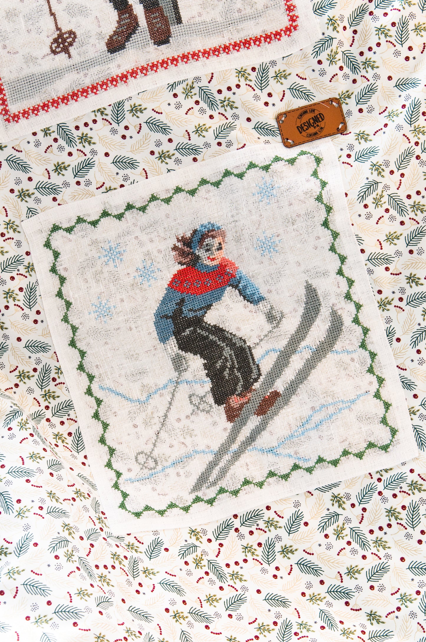 Grille de broderie point de croix : plaid skieurs années 30, silhouettes élégantes sur fond patchwork pastel. Imprimé couleur (Réf. DMC) sur 10 pages. Illustration Sylvie Teytaud.