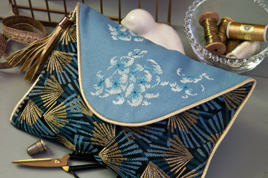 Grille de broderie point de croix : pochette de soirée aux motifs hortensias bleus. Motif 80 x 109 pts, imprimé couleur (Réf. DMC) sur 6 pages. Illustration Marie-Thérèse Saint Aubin.