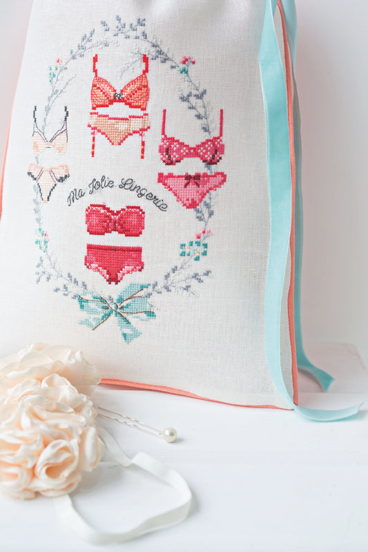 Grille broderie point de croix : pochon esprit boudoir, motif sous-vêtements féminins. 133x98 points, 4 pages, couleurs DMC. Lin blanc.