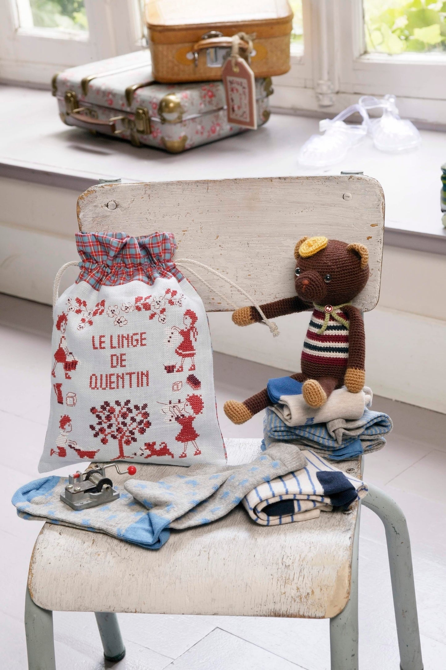 Grille broderie point de croix : pochon pour petit linge d'enfant. 90 x 89 pts, imprimée en couleur sur 4 pages. Réf. DMC incluses.