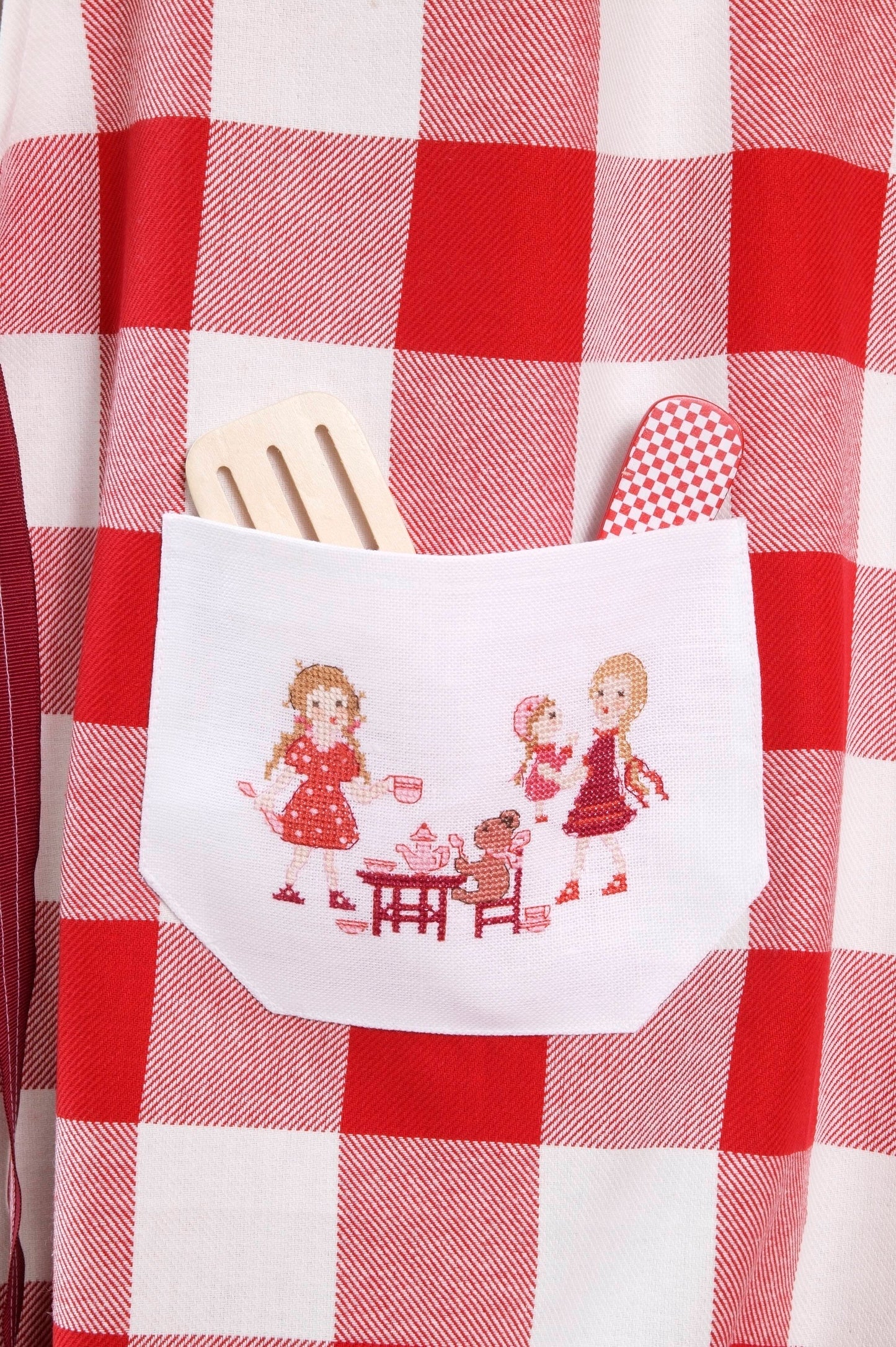 Grille broderie point de croix : tablier cuisine. 4 pages, symboles et couleurs DMC. Lin 12 fils blanc. 24,54 x 24,54 cm.