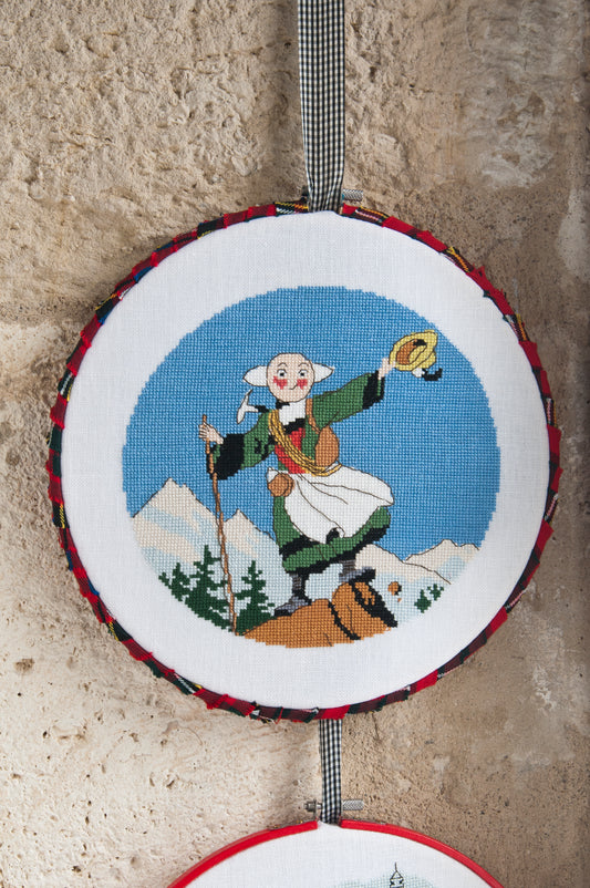 Grille broderie point de croix : tambours Bécassine en voyage (montagne), 3 motifs 70×70 pts. Symboles + couleurs DMC, 6 pages.