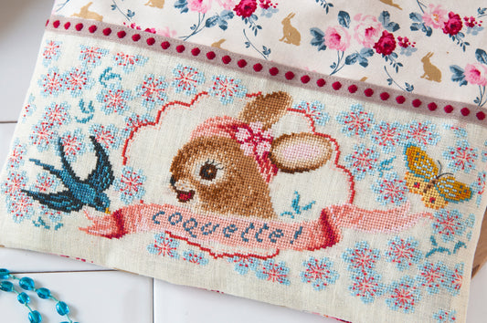 Grille point de croix : trousse coquette brodée d'une jolie demoiselle. 180 x 72 points, imprimée sur 4 pages avec symboles et couleurs DMC. Lin 11 fils.