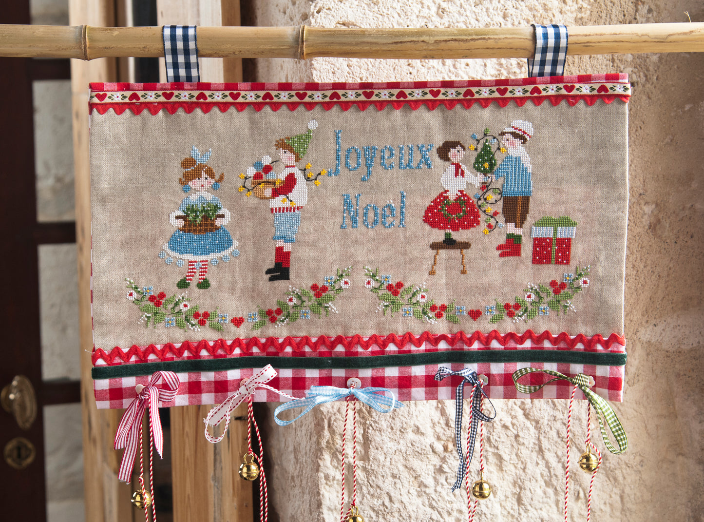 Grille de broderie point de croix : banderole de Noël à broder. Motif 252 x 123 pts, imprimé couleur (Réf. DMC) sur 6 pages. Illustration Lili Violette.