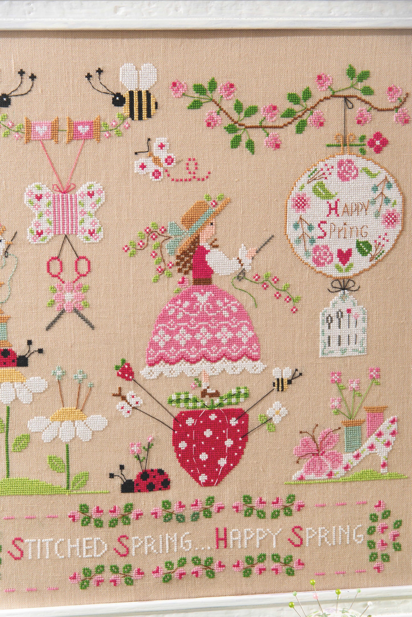 Grille point de croix : scène printanière, brodeuse, abeilles et fleurs. 210×240 pts, lin 12 fils/cm ou Aïda 6 pts/cm. 6 pages couleur, réf. DMC.