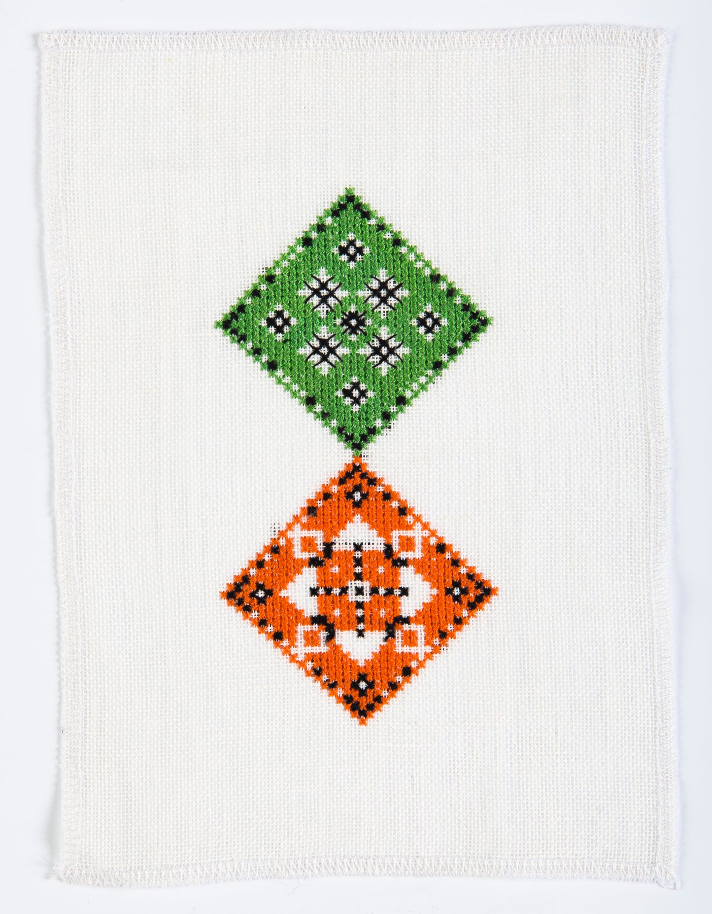 Grille point de croix – Une table au jardin, vue d'ensemble DMC : composition florale et géométrique en relief avec arrosoir, arbuste et gazon miniature sur toile de lin ivoire DMC – Création Point de Croix
