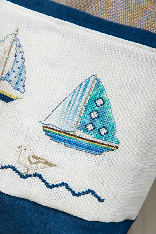 Grille broderie point de croix : sac de plage été. 4 pages, symboles et couleurs DMC. Lin 11 fils blanc. Sac terminé 43 x 55 cm.