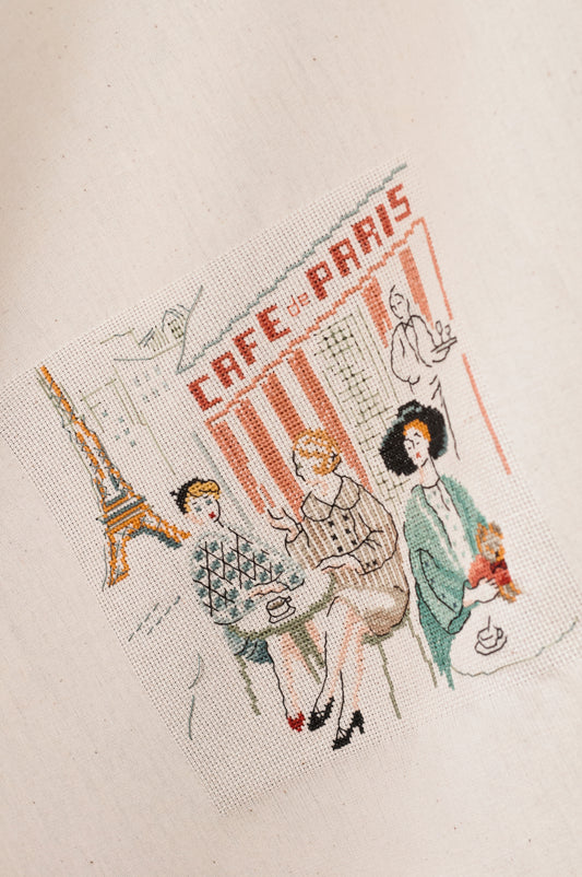 Grille broderie point de croix : terrasse de café parisien années 50 à broder sur Aïda blanc. Par M. Bonnin, DMC, 6 pages.