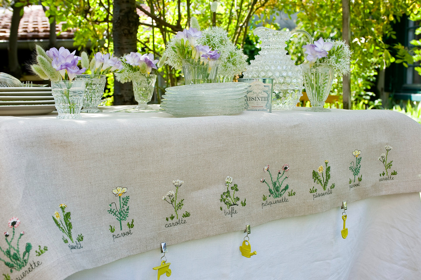 Grille broderie point de croix : nappe herbier avec pâquerettes, pissenlits, pavots et trèfles. Motifs sur lin 11 fils ou Aïda 5,5 pts. 4 pages. Ref. DMC.
