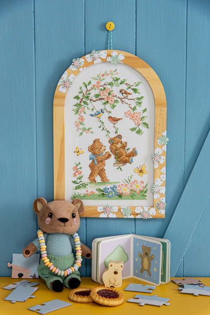 Grille point de croix Les Ours du Jardin Enchanté par Création Point de Croix. Oursons et fleurs brodés, DMC sur 6 pages. Format fini env. 5,8×27,3 cm sur Aïda.