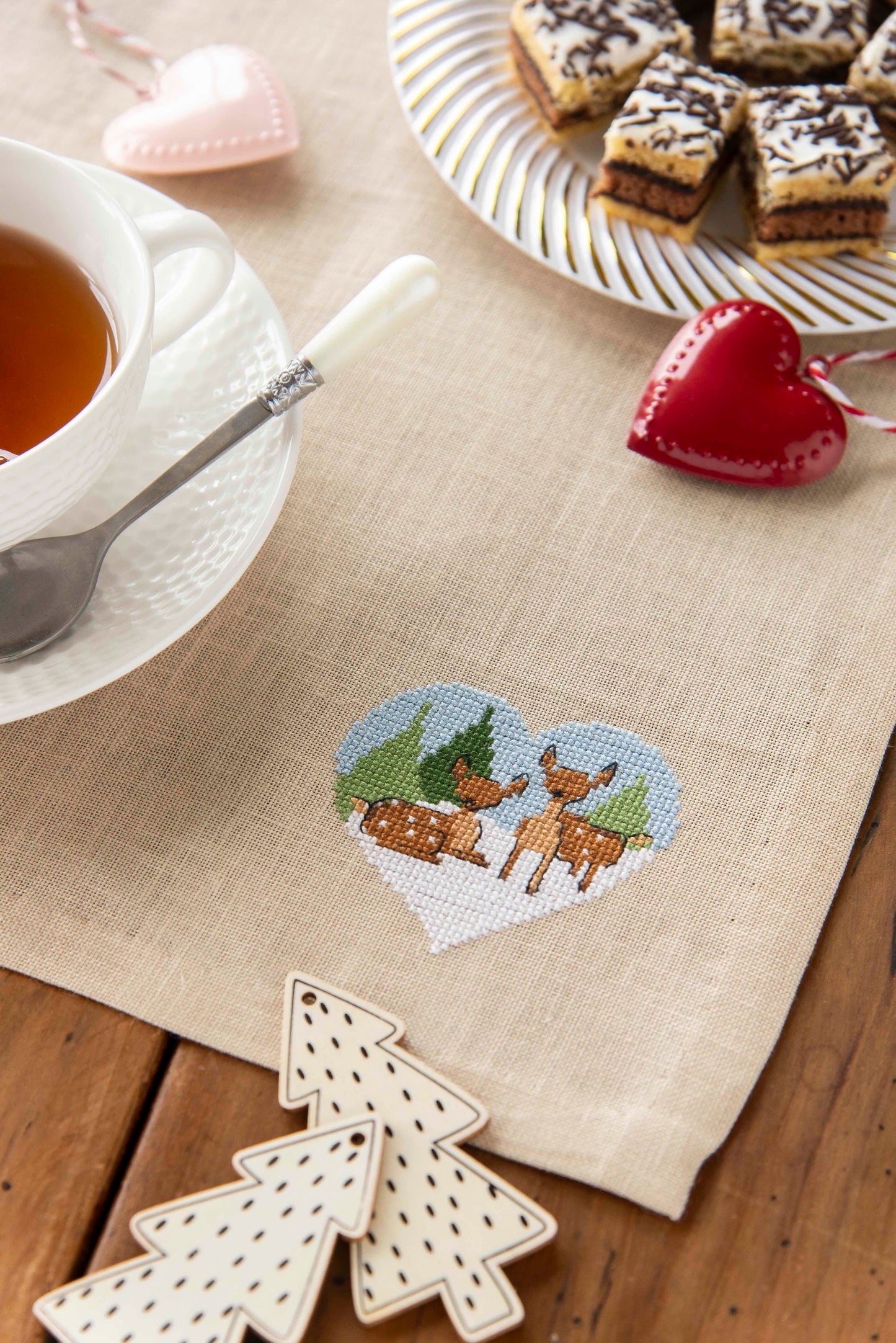 Grille broderie point de croix : petit faon dans un cœur fleuri. 46 x 44 pts, imprimée en couleur sur 2 pages. Réf. DMC incluses.
