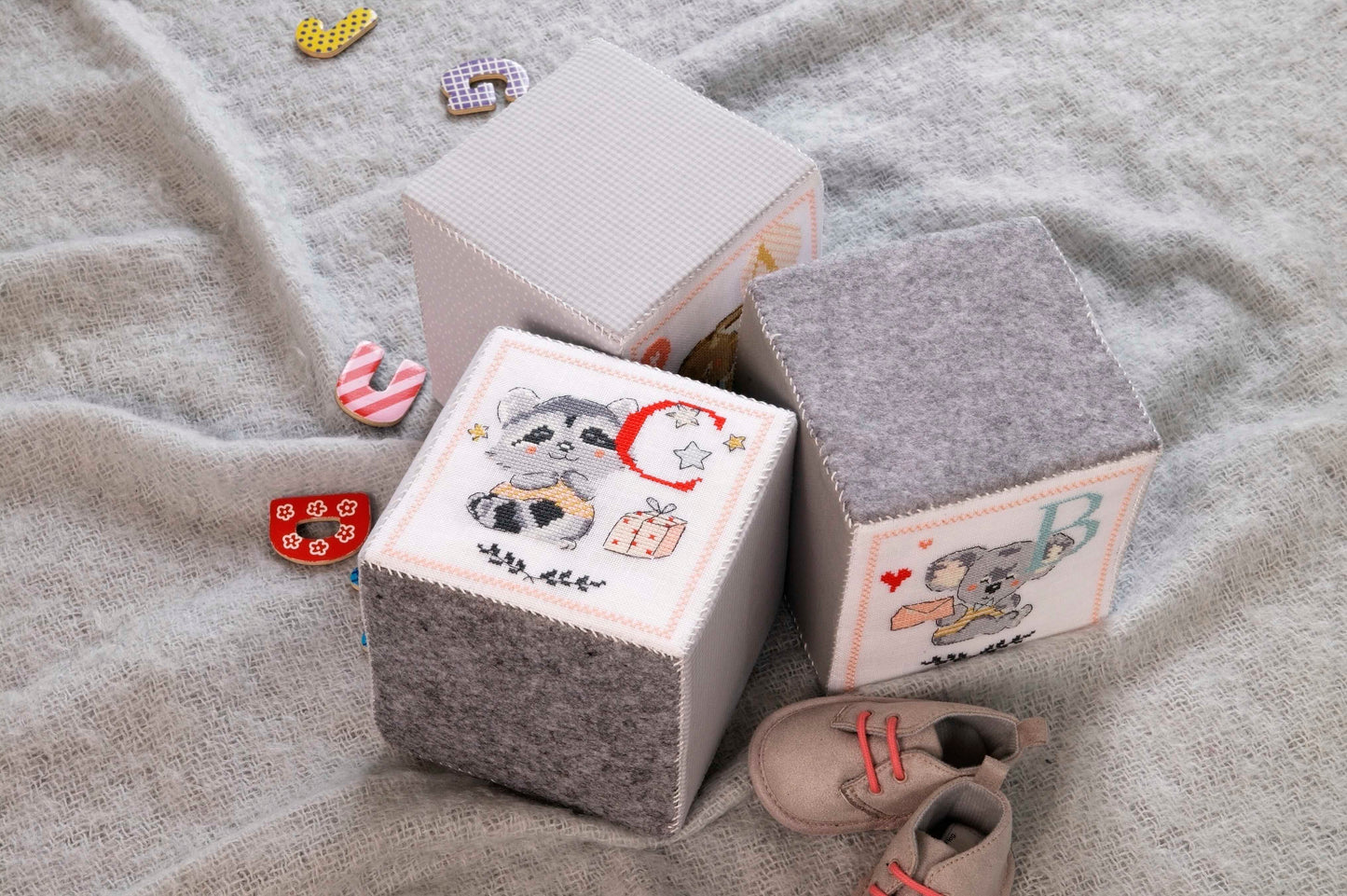 Grille de point de croix Tendres joujoux : cubes panda, lapinou et souricette sur lin 11 fils blanc. 29 x 108 points. Références DMC sur 6 pages.