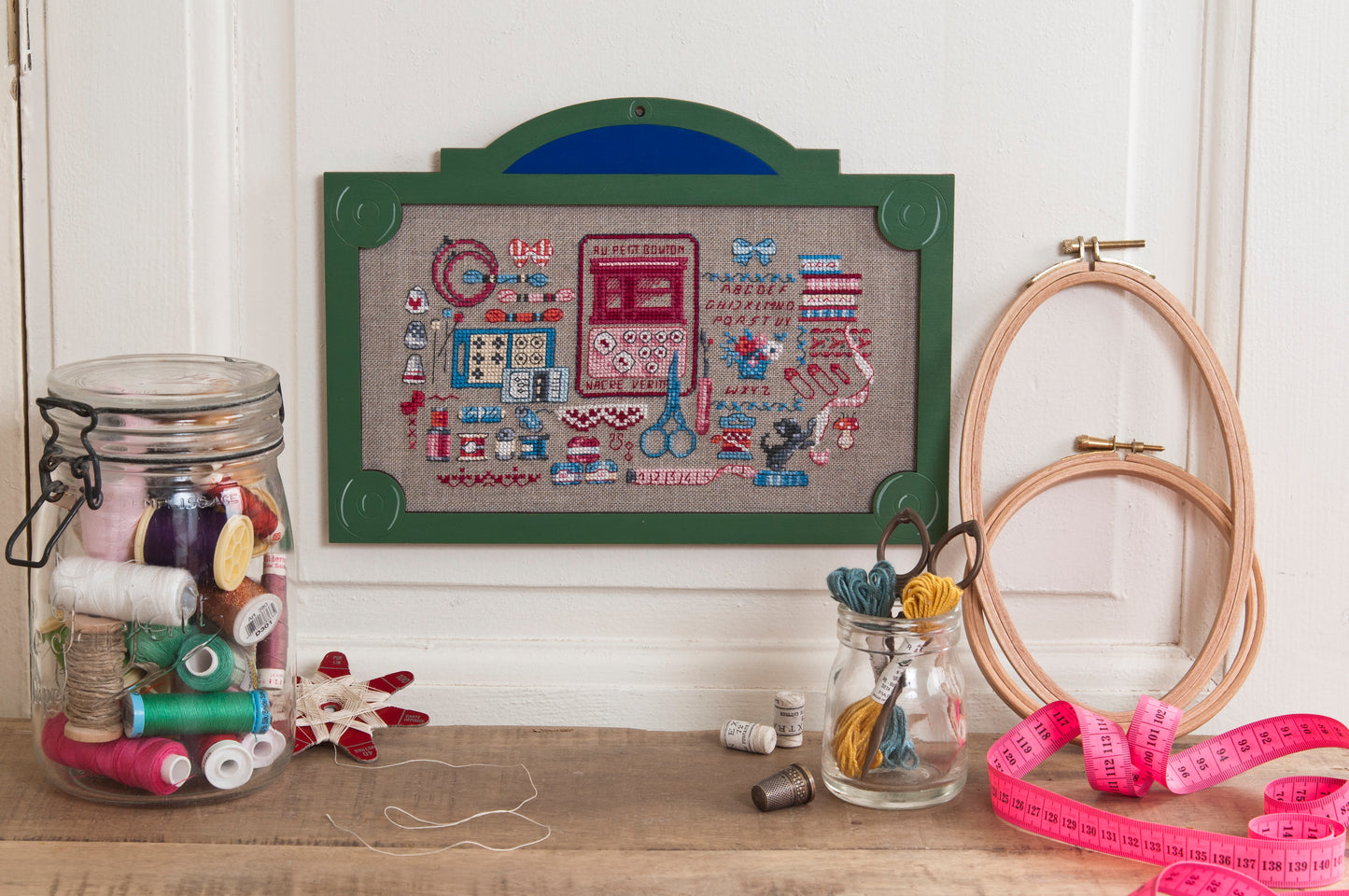 12 grilles broderie point de croix : plaques parisiennes Les boutiques par Véronique Enginger. 170×190 pts, env. 31×35 cm. Lin 11 fils/cm. Livret 16 pages DMC.