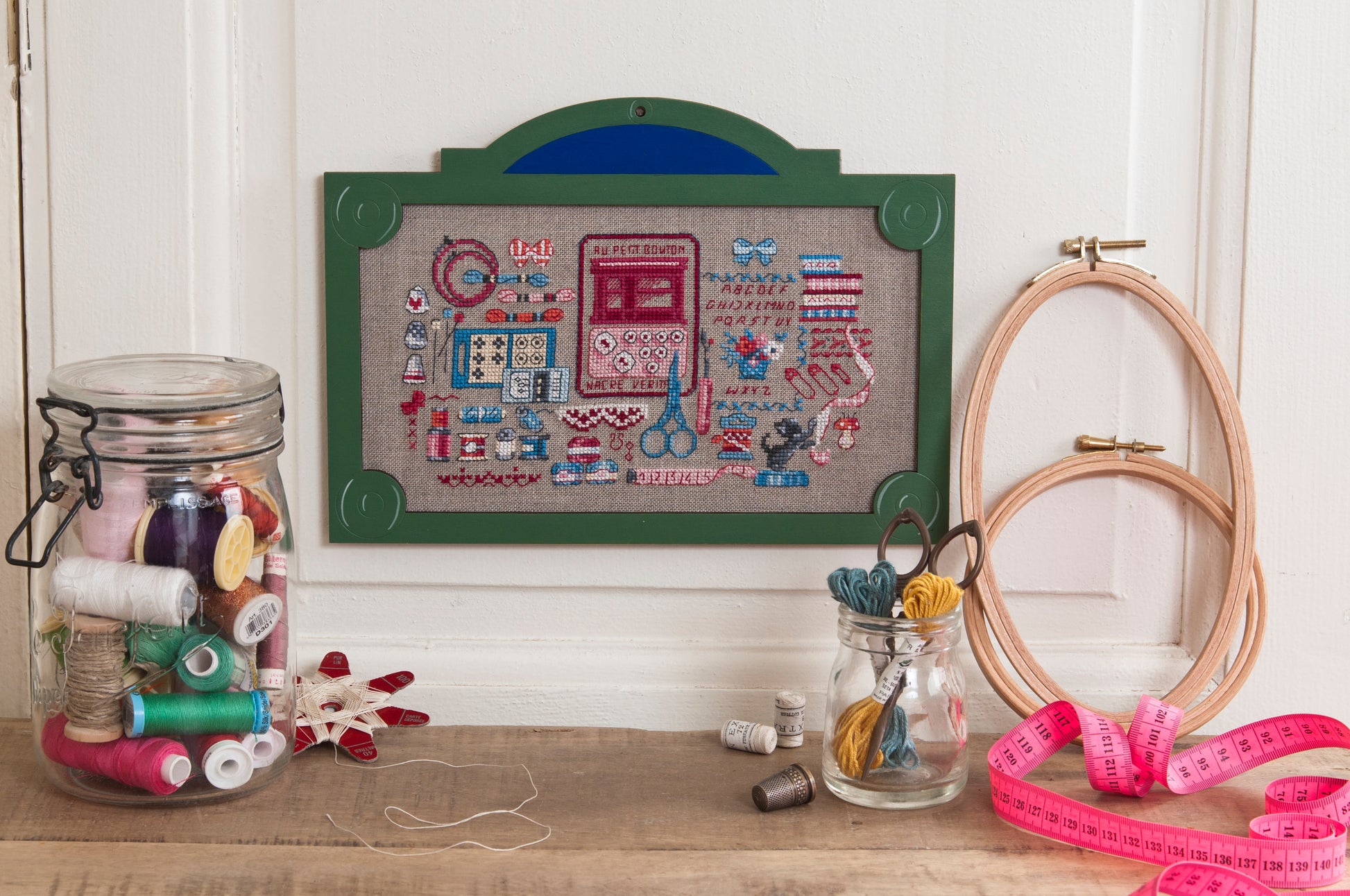 12 grilles broderie point de croix : plaques parisiennes Les boutiques par Véronique Enginger. 170×190 pts, env. 31×35 cm. Lin 11 fils/cm. Livret 16 pages DMC.