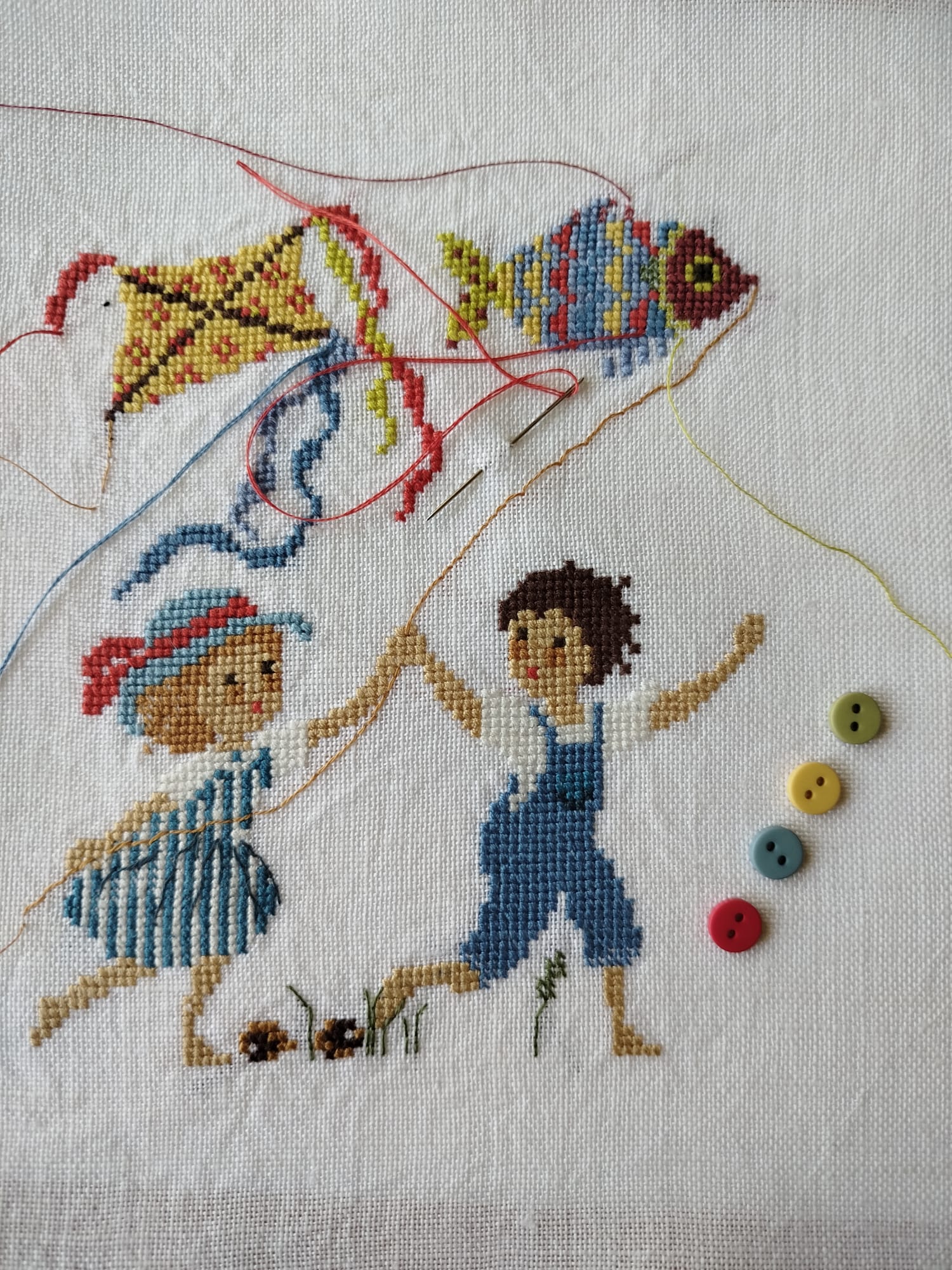 Grille point de croix avec enfants et cerfs-volants au bord de la mer, alphabet et chiffres inclus. Création de Perrette Samouiloff. 220 x 136 points, idéale pour chambre d'enfant.
