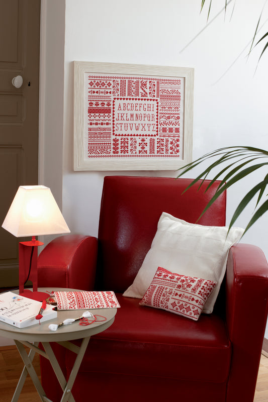 Grille broderie point de croix : abcédaire monochrome rouge et blanc, tradition des samplers. Imprimée sur 6 pages. Réf. DMC incluses.