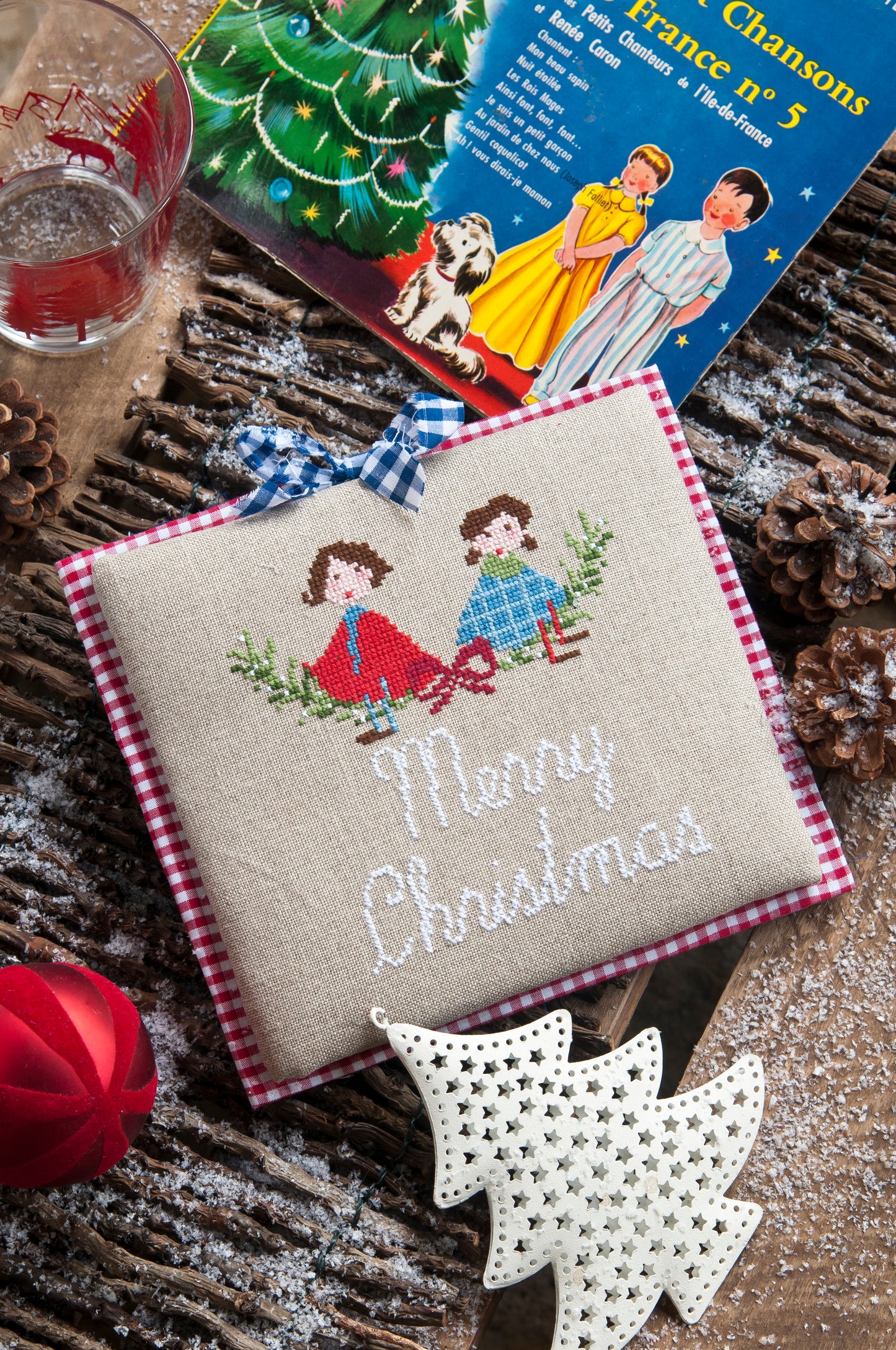 Grille de broderie point de croix « Merry Christmas » par Lili Violette : personnages en capes blanches sur lin bis 11 fils. DMC, 4 pages, motif 12,36 x 14,54 cm.