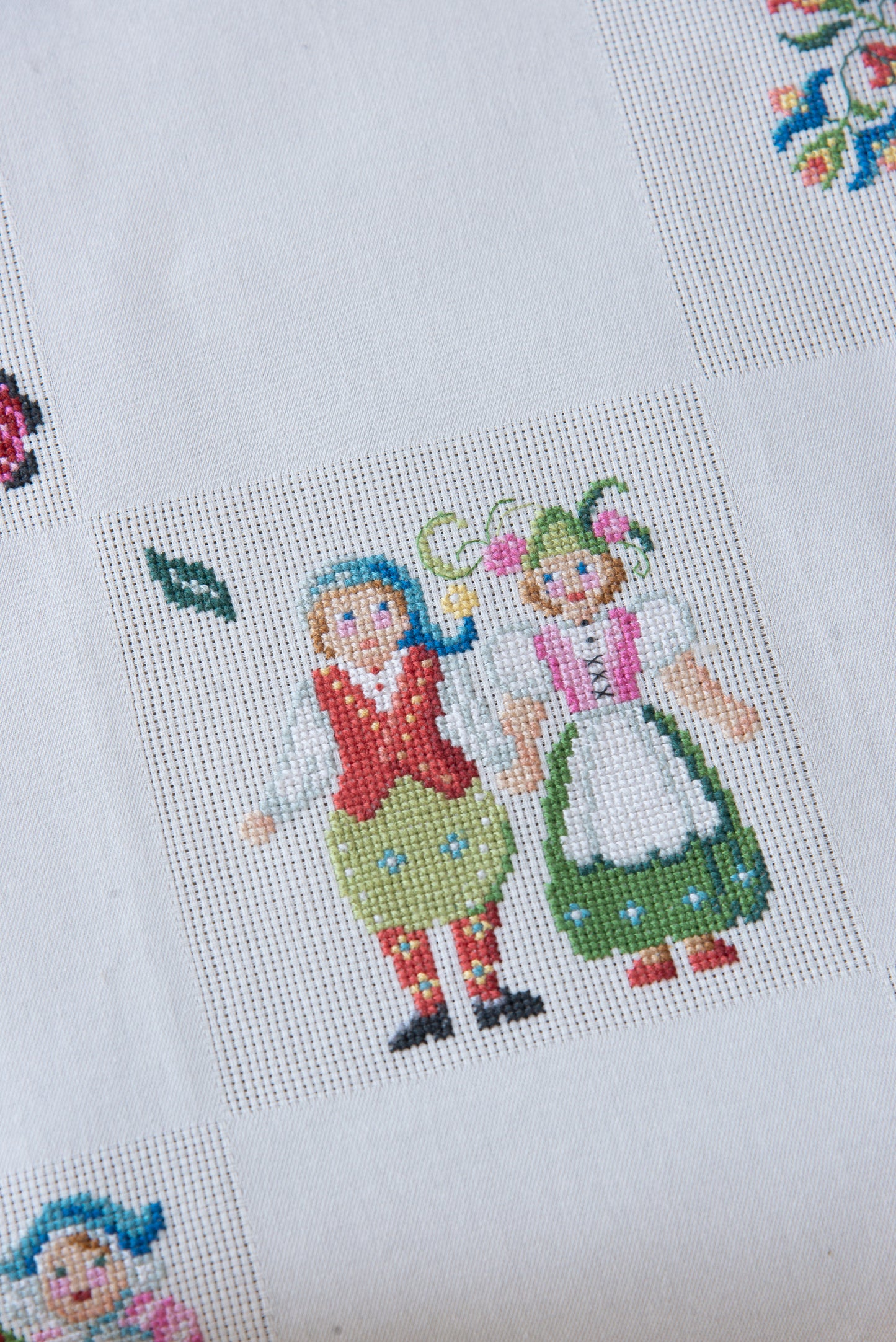 Grille de broderie point de croix « Nappe Tyrol » par M. Bonnin : personnages en costume tyrolien sur Aïda blanc 5,5 pts. DMC, 6 pages, motif 12,36 x 12,36 cm.