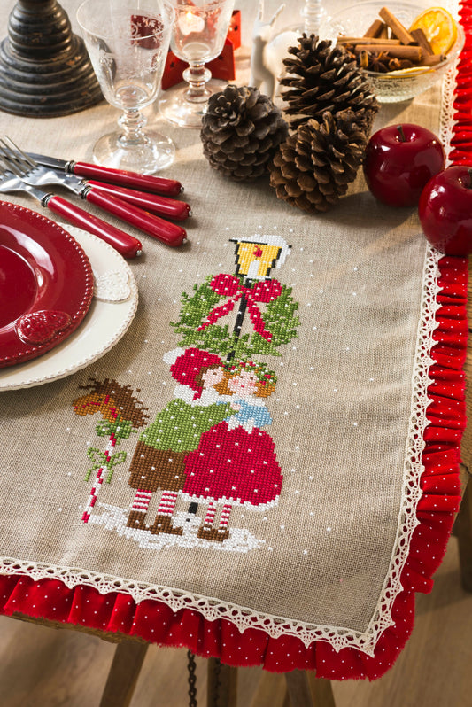 Grille de broderie point de croix : nappe de Noël aux amoureux sous la neige. 146x85 points, 6 pages, couleurs DMC. À broder sur lin bis.