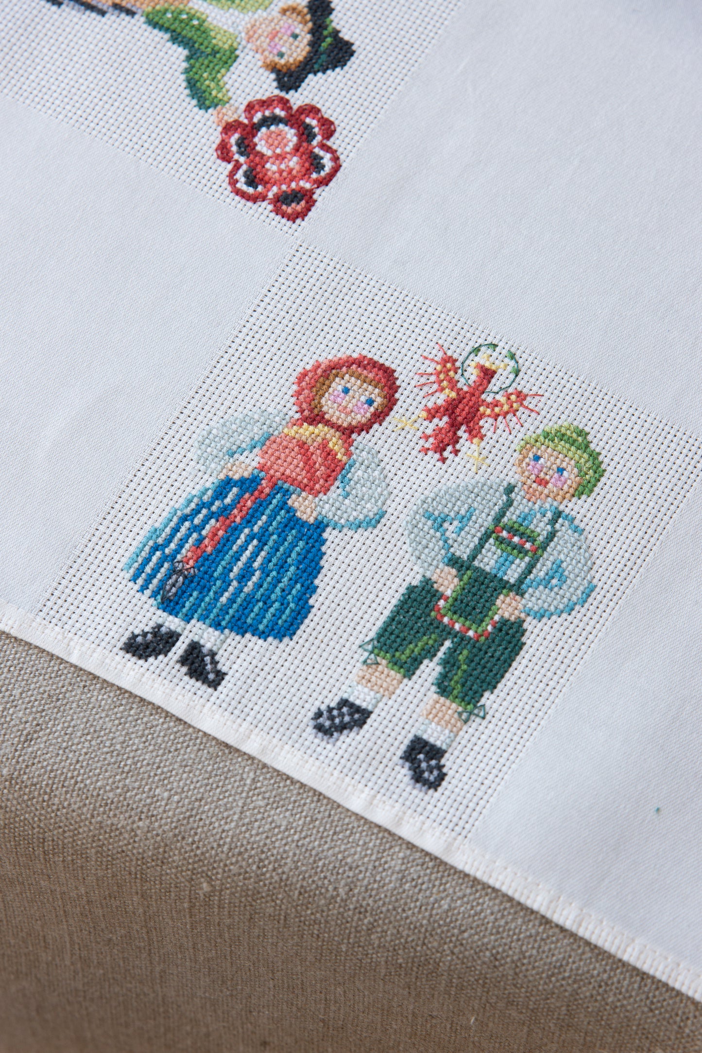 Grille de broderie point de croix « Nappe Tyrol » par M. Bonnin : personnages en costume tyrolien sur Aïda blanc 5,5 pts. DMC, 6 pages, motif 12,36 x 12,36 cm.