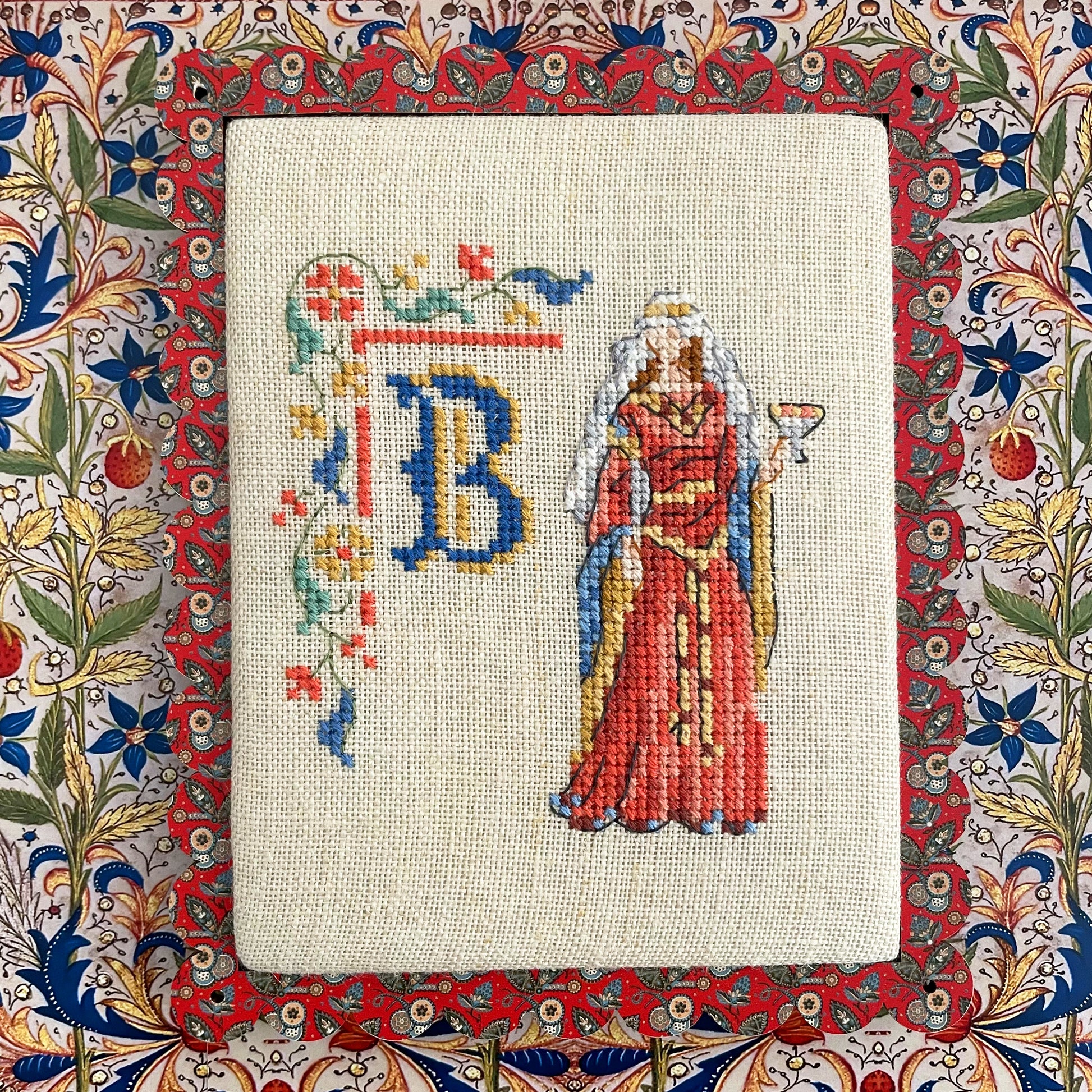 Grille point de croix : alphabet médiéval, damoiselles et motifs floraux. 52×52 pts, lin 11 fils/cm ou Aïda 5,5 pts/cm. 6 pages couleur, réf. DMC.