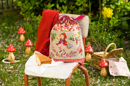 Grille point de croix Mon Petit Sac à Dos Fleuri par Création Point de Croix. Sac enfant chaperon rouge, DMC sur 6 pages. Format fini env. 14,5×23,5 cm sur lin.