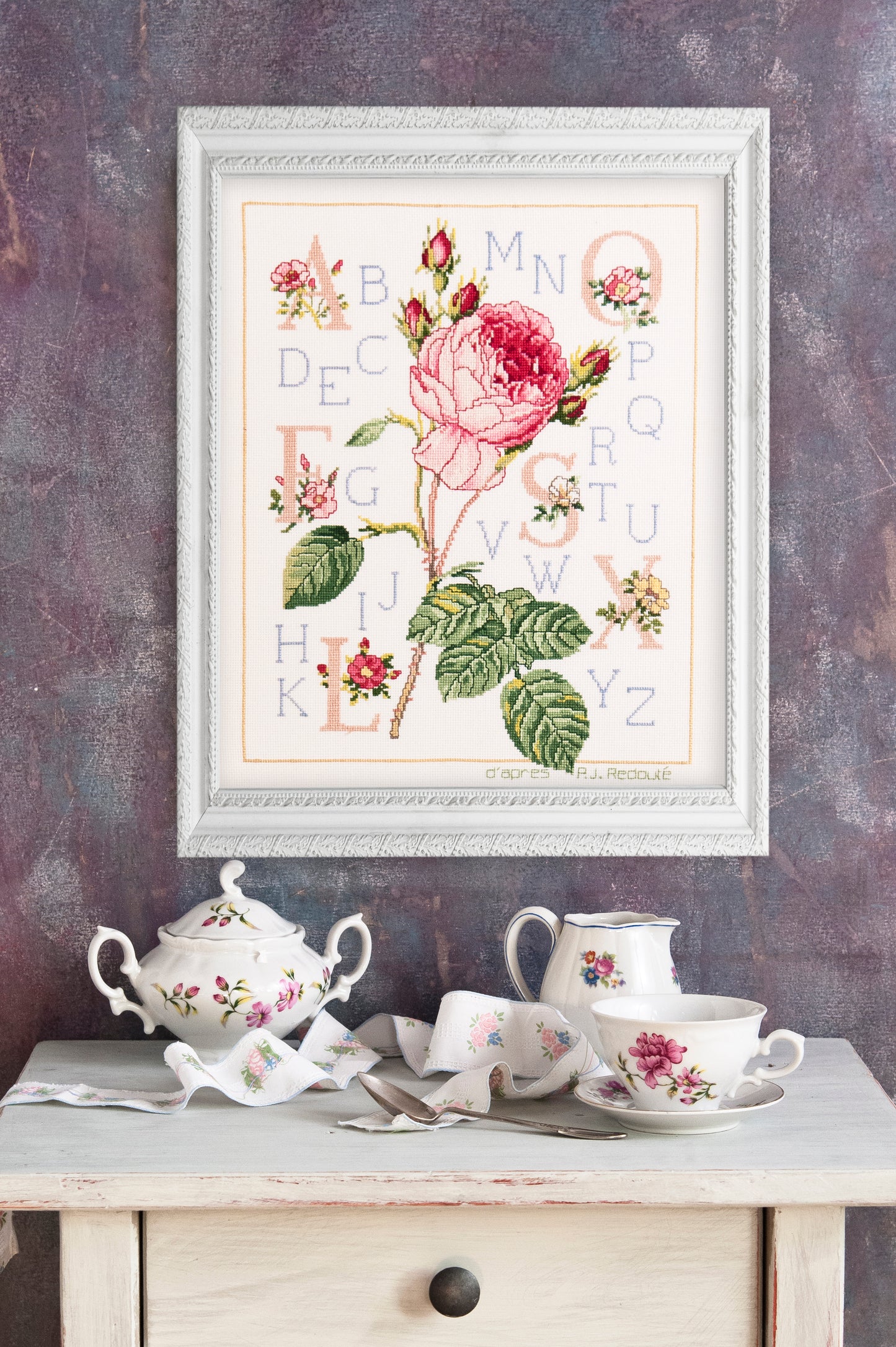 Grille point de croix – Abécédaire rose : grande rose épanouie inspirée de Redouté, boutons et feuillages finement dessinés entourant un alphabet élégant sur toile de lin – DMC & Création Point de Croix