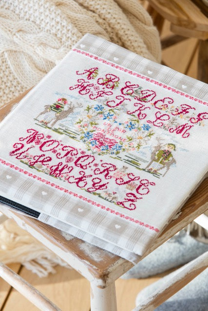 Grille de broderie point de croix : album photos « un air de montagne », abécédaire fleuri, 122x128 points sur 6 pages. Symboles et couleurs DMC.