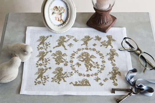 Angelots délicats en monochrome écru brodés sur lin blanc, signés M. Bonnin. Motif romantique et intemporel, 21,8 × 18,2 cm, esprit linge ancien et campagne chic.
