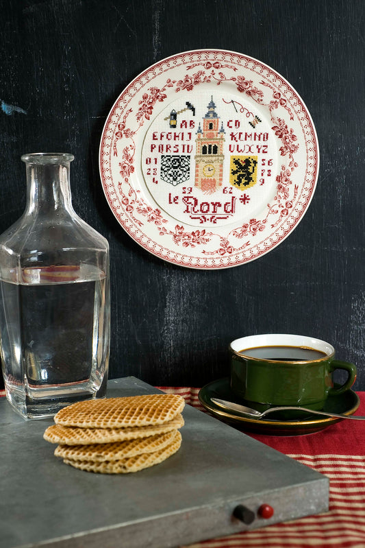 Grille broderie point de croix : assiette symboles du Nord, lion des Flandres et beffroi. Motif 84x84 pts, env. 15x15 cm sur Aïda 7 pts ou lin 11 fils. Ref. DMC.