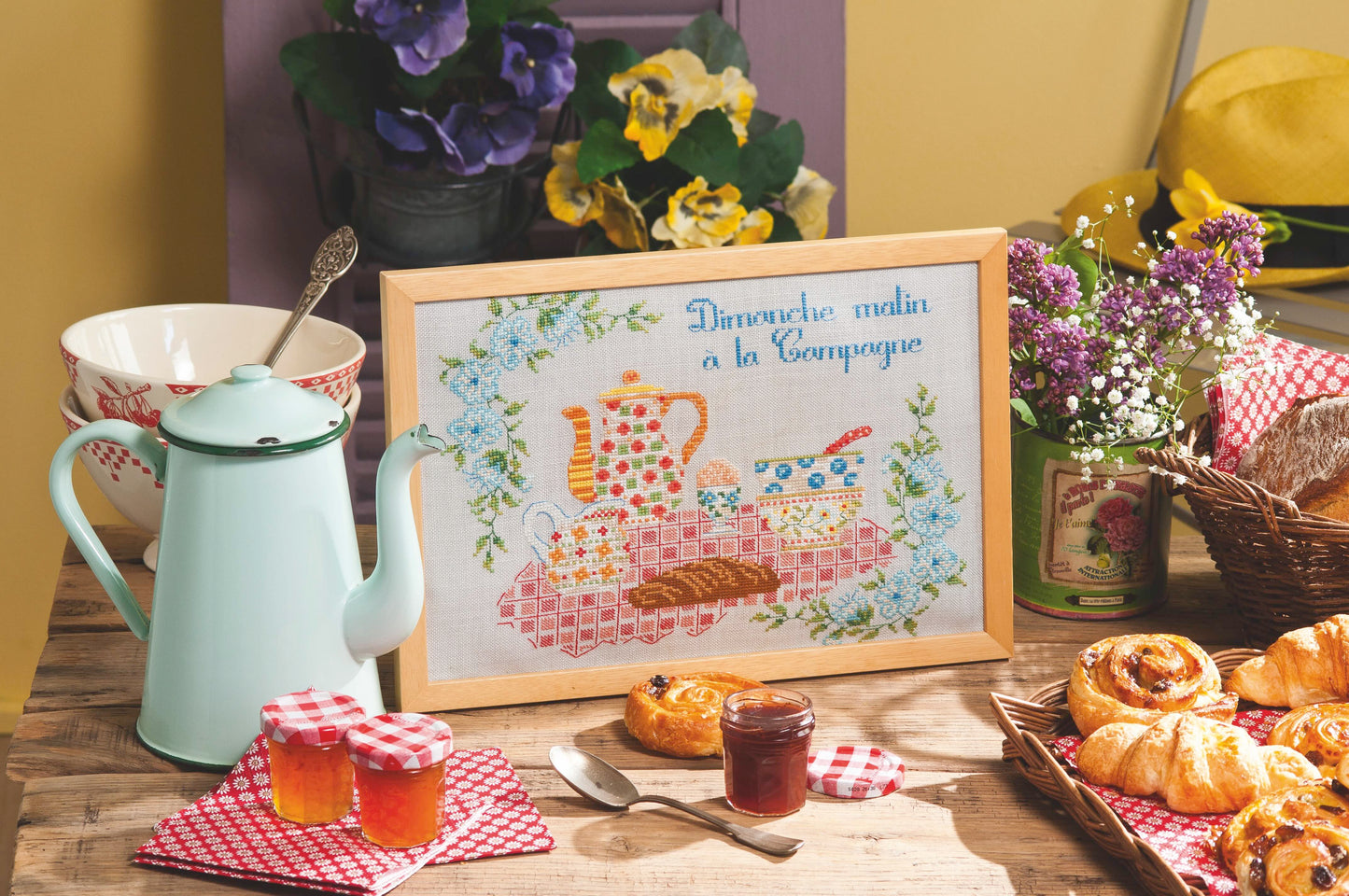 Grille point de croix – Au petit matin : scène de petit-déjeuner campagnard avec bols colorés, nappe à carreaux et accessoires de cuisine brodés sur toile de lin perle 12 fils/cm, ambiance maison de campagne chaleureuse – Marie-Anne Réthoret-Mélin & Création Point de Croix