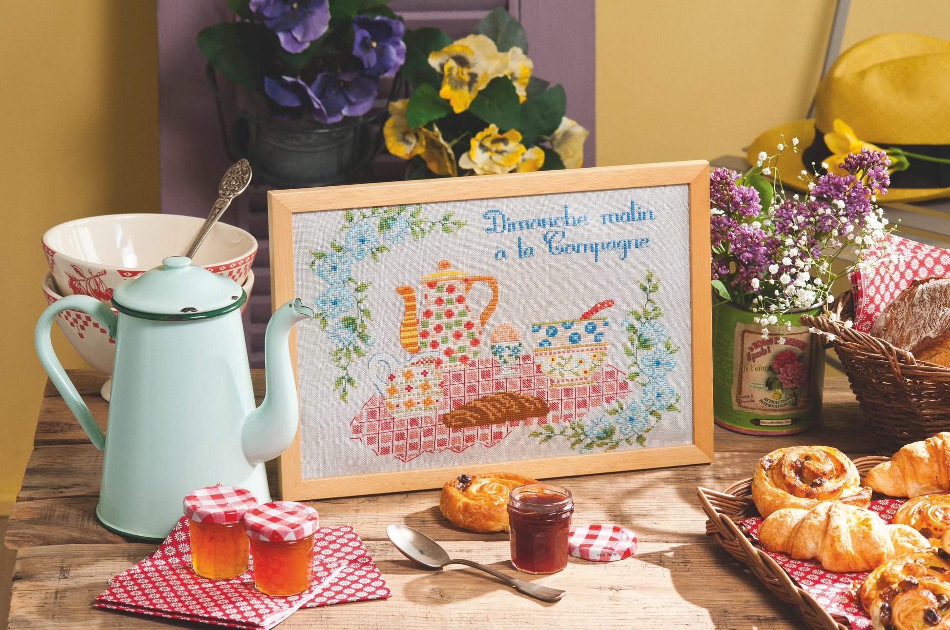 Grille point de croix – Au petit matin : scène de petit-déjeuner campagnard avec bols colorés, nappe à carreaux et accessoires de cuisine brodés sur toile de lin perle 12 fils/cm, ambiance maison de campagne chaleureuse – Marie-Anne Réthoret-Mélin & Création Point de Croix