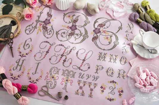 Grille point de croix – Belles lettres : alphabet élégant brodé en tons clairs sur toile de lin rose cyclamen 12 fils/cm, style marquoir romantique et raffiné – DMC & Création Point de Croix"