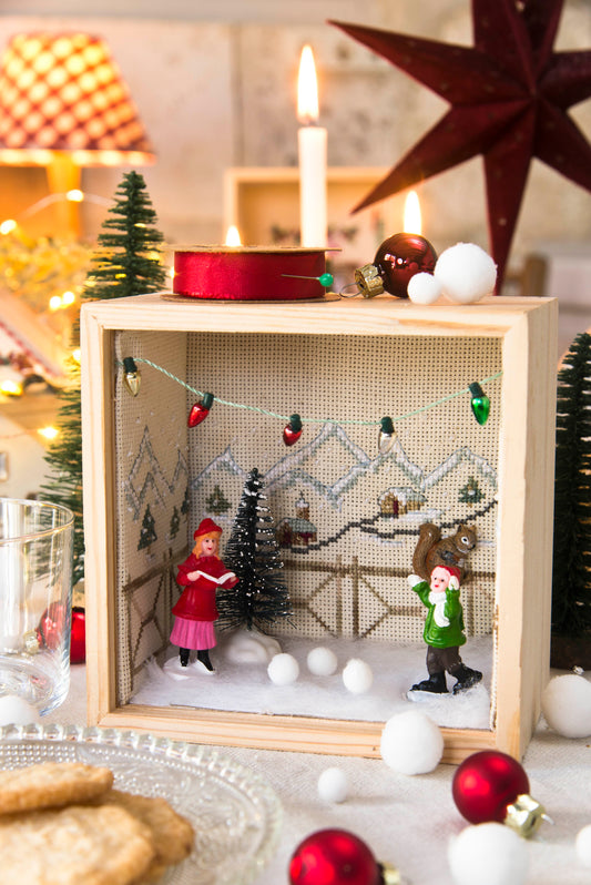 Grille de point de croix Bientôt Noël : vitrines, boîtes et miniatures sur Aïda 7 pts ivoire. Références DMC sur 6 pages.