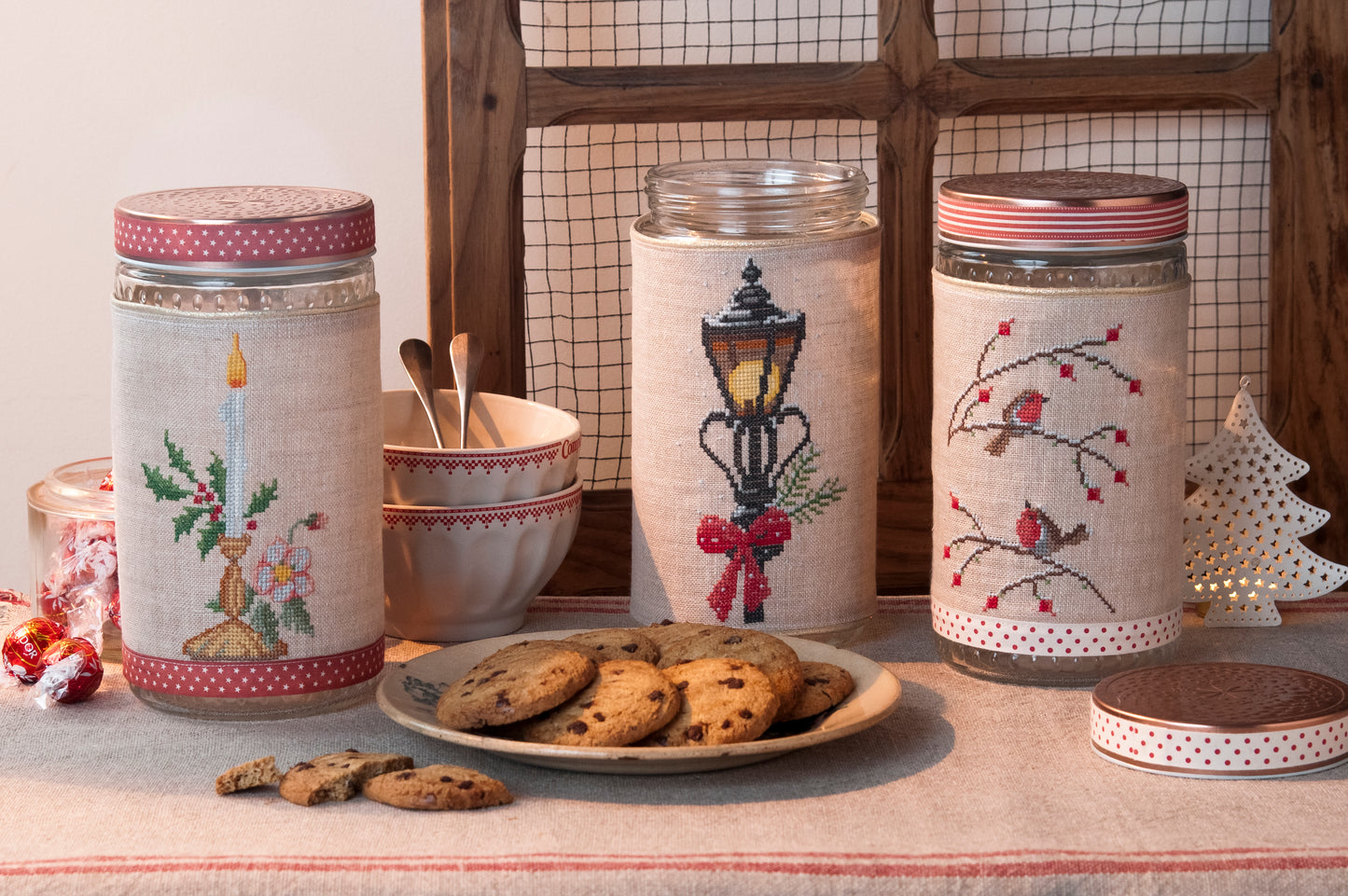 Grille de broderie point de croix : biscuits de Noël sur pots en verre (bougie, branche, réverbère). Imprimé couleur (Réf. DMC) sur 6 pages.